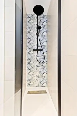 a shower with a glass door with a wall at Apartamentos Río Turia in Valencia