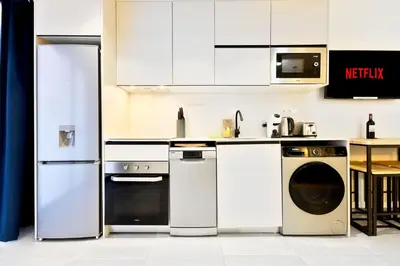 a kitchen with white appliances and a table at Apartamentos Río Turia in Valencia