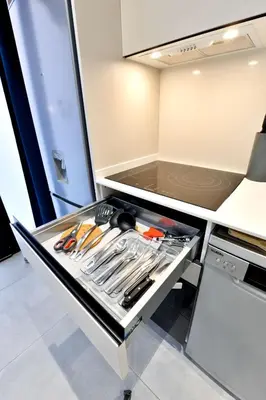 a kitchen with an open drawer with utensils at Apartamentos Río Turia in Valencia
