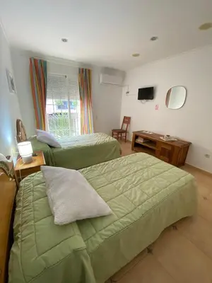 a hotel room with two beds and a television at Casa Rural Roa in Casinos