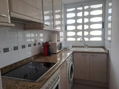 a kitchen with a sink and a microwave at Cullera apartamento junto al mar in Cullera
