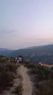 a group of people walking down a dirt trail at Refugio La Presa in Chulilla