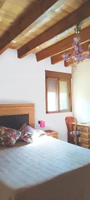 a bedroom with a bed and a table and a chair at Refugio La Presa in Chulilla