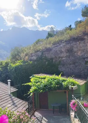 a house with a table and a bench next to a hill at Refugio La Presa in Chulilla