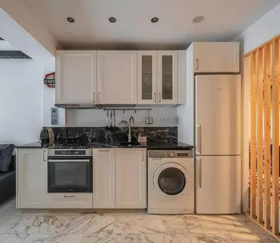 a kitchen with white cabinets and a washer and dryer at Luxury loft on the beach in Valencia