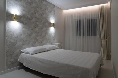 a bedroom with a white bed and a wall at Apartamento mar&menta in Cullera