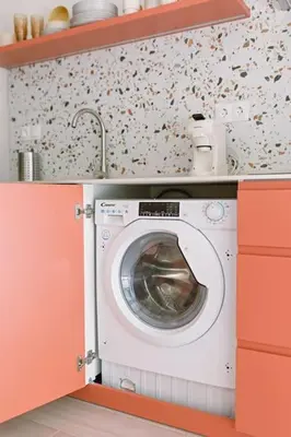 a washing machine in a kitchen with orange cabinets at Park Central loft. Ruzzafa. in Valencia