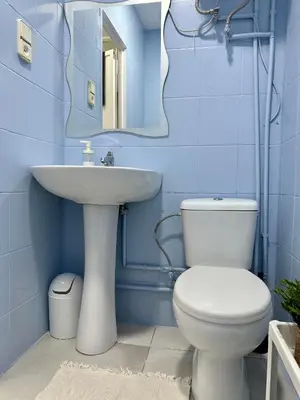 a blue bathroom with a toilet and a sink at The Valencia Stop in Valencia