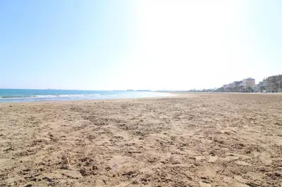 an empty beach with footprints in the sand at Global Vacacional, Practico apartamento para 6 personas en Puerto Sagunto in Puerto de Sagunto
