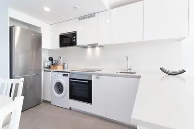 a white kitchen with a washer and dryer at Global Vacacional, Apartamento con 2 terrazas en Gran Canet in Canet de Berenguer