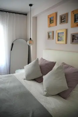 a bedroom with a bed with four pillows on it at Luxury apartment Y after renovation in Cullera with parking in Cullera