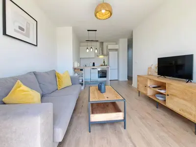 a living room with a gray couch and a tv at Charming flat close to the beach in Canet de Berenguer