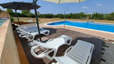 a group of chairs and an umbrella next to a swimming pool at Posada la Toscana in Montroy