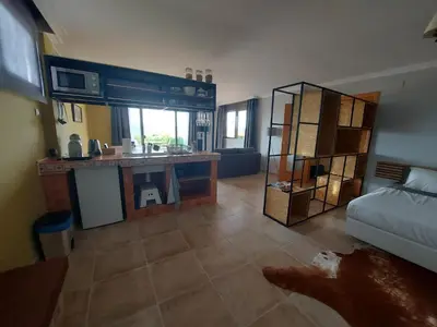 a large room with a kitchen and a bedroom at Posada la Toscana in Montroy