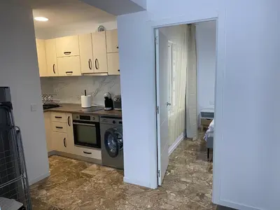 a kitchen with white cabinets and a washer and dryer at Del Mar one bed flat in Puerto de Sagunto
