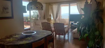 a living room with a table and chairs and a couch at Espectacular terraza y vistas en 1a línea de playa in Cullera