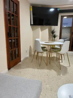 a dining room with a table and chairs and a television at Modern apartment in Valencia, Port Saplaya, by the sea in Port Saplaya