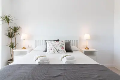 a bedroom with a white bed with towels on it at Global Vacacional, Bonito apartamento con terraza en Gran Canet in Canet de Berenguer