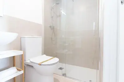 a bathroom with a toilet and a glass shower at Global Vacacional, Nuevo apartamento con terraza en Gran Canet Residencial in Canet de Berenguer