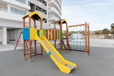 a playground with a slide in front of a building at Global Vacacional, Nuevo apartamento con terraza en Gran Canet Residencial in Canet de Berenguer