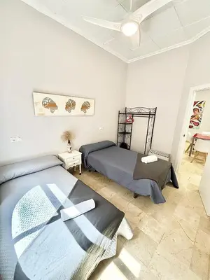 a bedroom with two beds and a ceiling fan at Apartamentos Bobal Requena in Requena