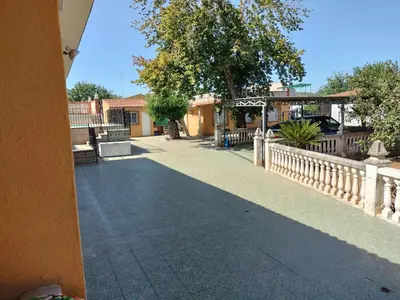 a walkway next to a building with a fence at Villa les palmiers in Rafelguaraf