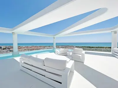 a white living room with a view of the ocean at Gran Apartment in Canet de Berenguer