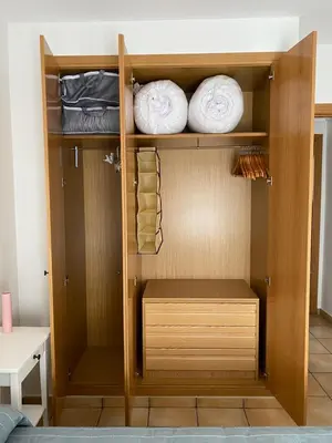 a closet with wooden shelves and white towels at Residencial Playa Canet in Canet de Berenguer