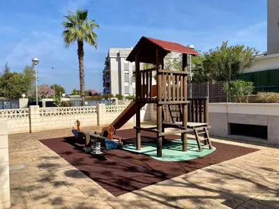 a wooden playground with a slide in a park at Residencial Playa Canet in Canet de Berenguer