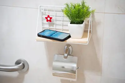 a cell phone and a potted plant on a shelf in a bathroom at Fantastic apartment near beach & Science City in Valencia
