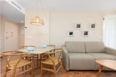 a living room with a couch and a table and chairs at Apartamentos Las Ciencias I in Valencia