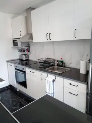 a kitchen with white cabinets and a sink at Spacious, 2 BR/2 BA, 3 Min walk to the beach in Cullera