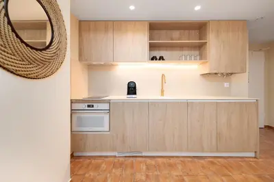 a kitchen with wooden cabinets and a mirror at Apartamentos Las Ciencias L in Valencia