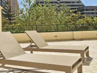 two chairs and a bench on a patio at Apartamentos Las Ciencias S in Valencia