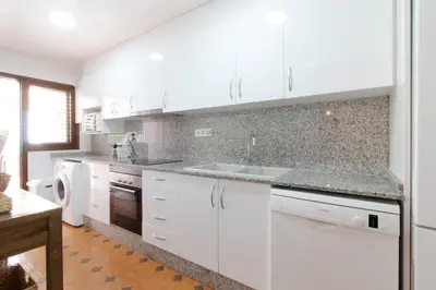 a kitchen with white cabinets and a sink at Global Vacacional, Adosado con piscina en la playa de Canet in Canet de Berenguer