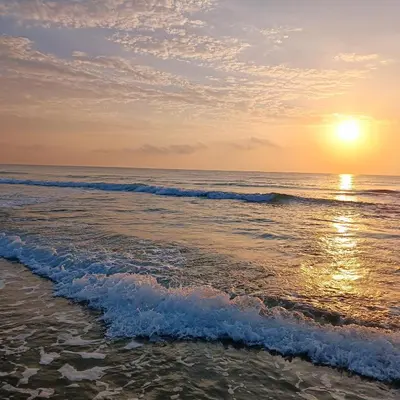 a sunset on the beach with the ocean at Mareny de Barraquetes in Mareny Blau