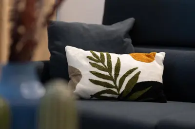 a blue couch with a pillow on it with a plant at DormForYou Alameda 12 Apartment in Valencia