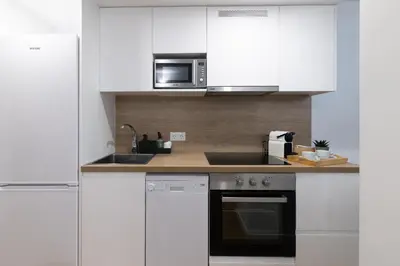 a kitchen with white cabinets and a microwave at DormForYou Alameda 12 Apartment in Valencia