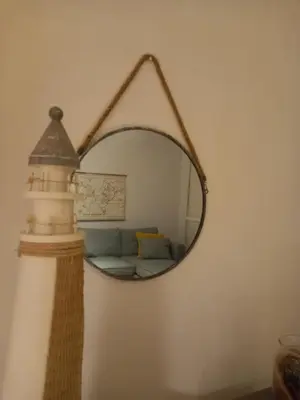 a mirror hanging on a wall next to a lighthouse at Apartamento Analema con piscina wifi y aire acondicionado in Moncófar
