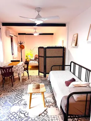 a bedroom with two beds and a living room at Cozy apartamento en Ruzafa para 2-3 personas con aire acondicionado y salida directa a terraza in Valencia