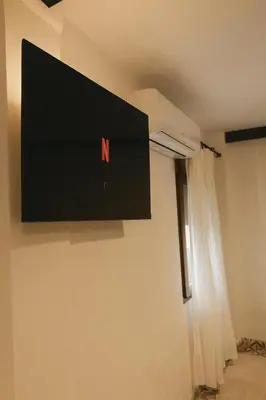 a television hanging on a wall in a room at Cozy apartamento en Ruzafa para 2-3 personas con aire acondicionado y salida directa a terraza in Valencia