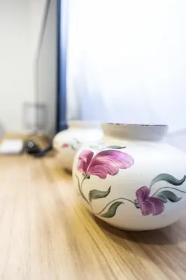 two white vases with flowers on a wooden floor at La casita de pescadores by Concept Flats in Valencia