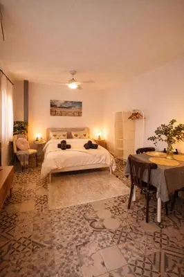 a bedroom with a large bed and a table and a table sidx sidx at Precioso apartamento con a/a en Ruzafa con terracita privada y acceso a un jardín, para 2-3 personas in Valencia