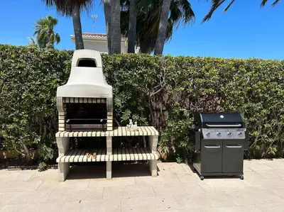 a grill and a stove sitting next to a bush at Exquisita Villa Frente al Mar in Sagunto