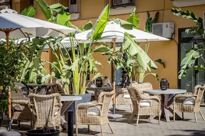 an outdoor patio with tables and chairs and umbrellas at Palacio de Rojas by Moontels in Valencia
