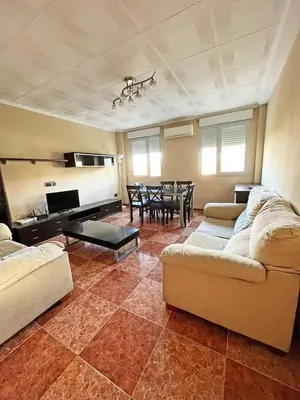 a living room with a couch and a dining room at Bonito y grande apartamento cerca de la playa in Valencia