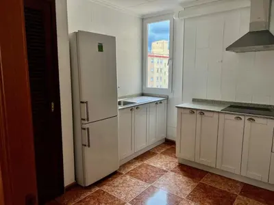 a white kitchen with a refrigerator and a window at Bonito y grande apartamento cerca de la playa in Valencia