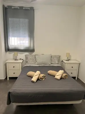 a bed with three pillows on it with two night stands at dama iberica II in Valencia