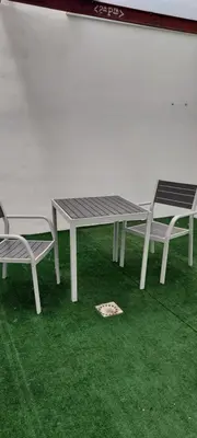 a picnic table and two chairs on green grass at dama iberica II in Valencia