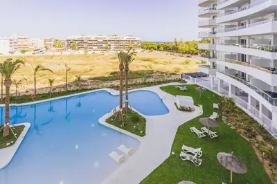 an overhead view of a swimming pool with palm trees and a building at Luxury Apartment with 2 Bedrooms in Canet d'en Berenguer, Valencia in Canet de Berenguer